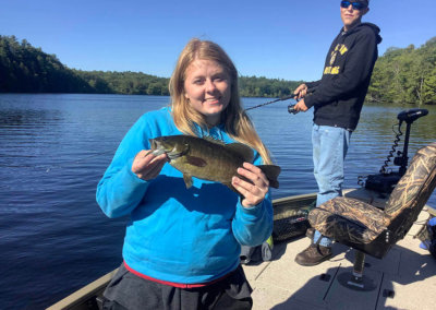 Maine bass fisherwoman showing off her catch