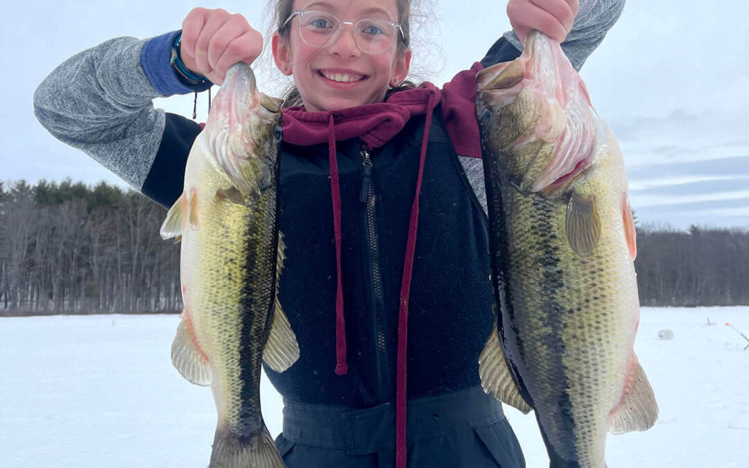 A young girl showing off her catch ice fishing