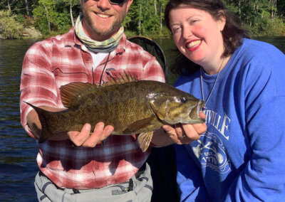 Jon with visiting fisherwoman showing off her catch on a Sebago Lake fishing trip