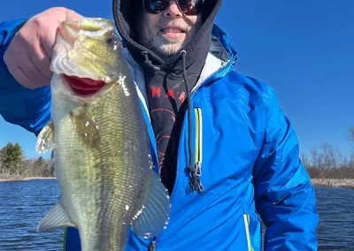A happy angler showing off his fish he caught in Sebago Lake