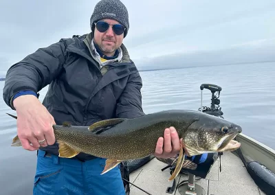 A fisherman showing off his fish after a day fishing on Sebago Lake