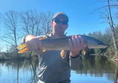 A happy angler shows off his catch after a day fishing on Sebago Lake