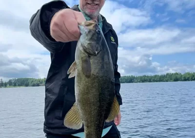 A fisherman showing off his catch at Sebago Lake