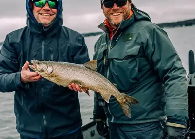 Jon with a happy fisherman, showing off his catch after a day on Sebago lake