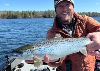 Jon Peterson showing off his catch on a Sebago Lake Fishing trip