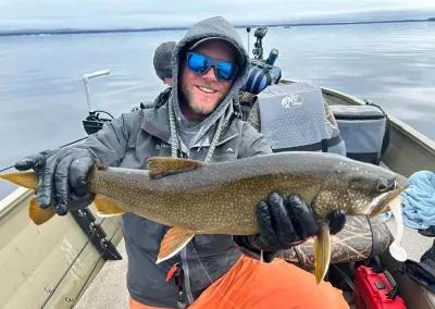 Guide Jon Peterson showing off his catch on a Sebago Lake Fishing trip